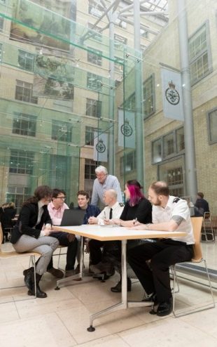 Pictured are male and female service and MOD Civilian personnel. They are in a meeting room in MOD Main Building in London.