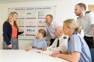 Pictured are male and female service and MOD Civilian personnel. They are in a meeting room in MOD Main Building in London.