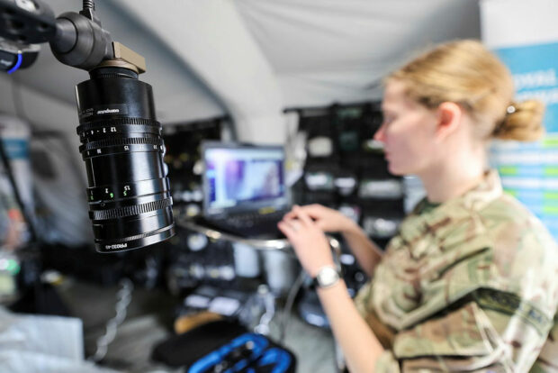 woman in the background and a microscope in the foreground